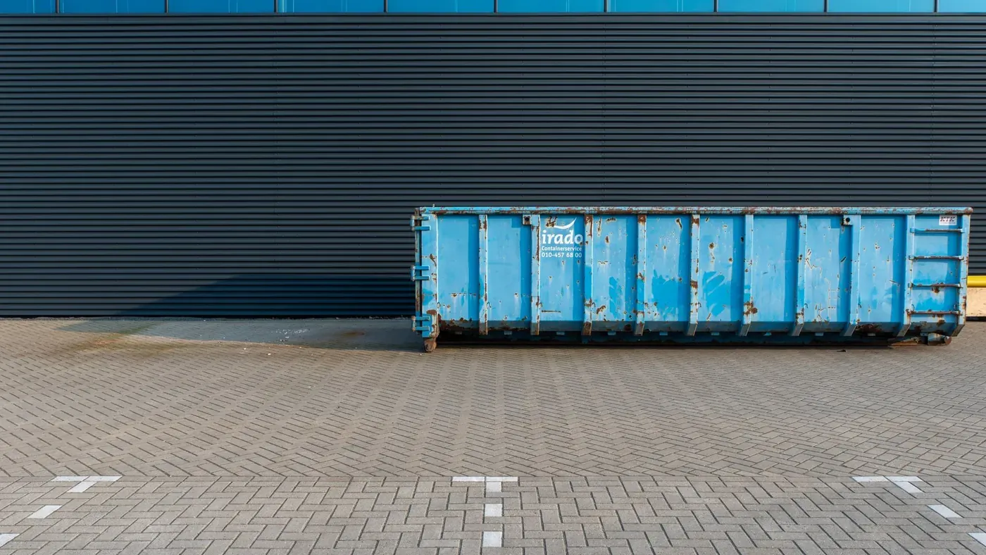 Absetzcontainer für Bauschutt neben einer Gebäudefassade